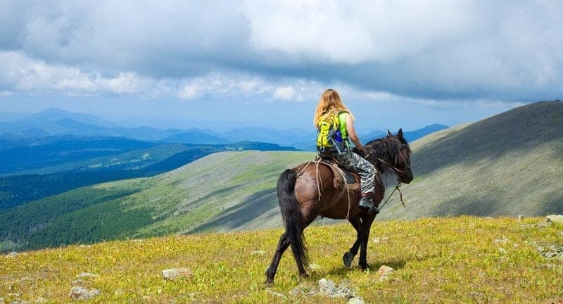 Woman horseback riding in the mountains