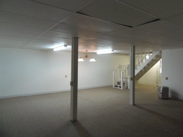 A basement with white walls and carpet at a cabin in Murphy NC.
