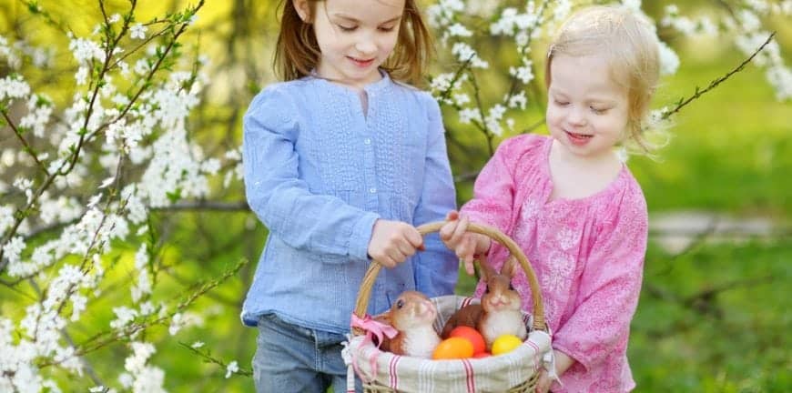 Young sisters holding an Easter basket near their cabin rental in the mountains of North Carolina
