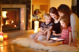 Family using a tablet by the fireplace at their Murphy NC cabin with internet access.