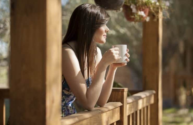 Woman enjoying a cup of coffee on the porch of one of our Murphy North Carolina vacation rentals.