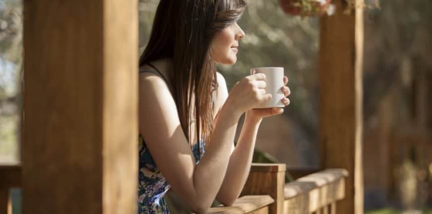 Woman enjoying a cup of coffee on the porch of one of our Murphy North Carolina vacation rentals.