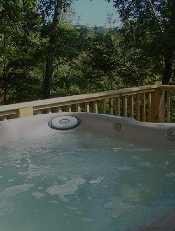 A bubbly hot tub on the deck of a Murphy NC cabin rental.
