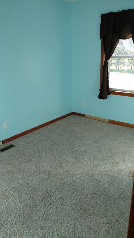 blue bedroom with carpet and a window
