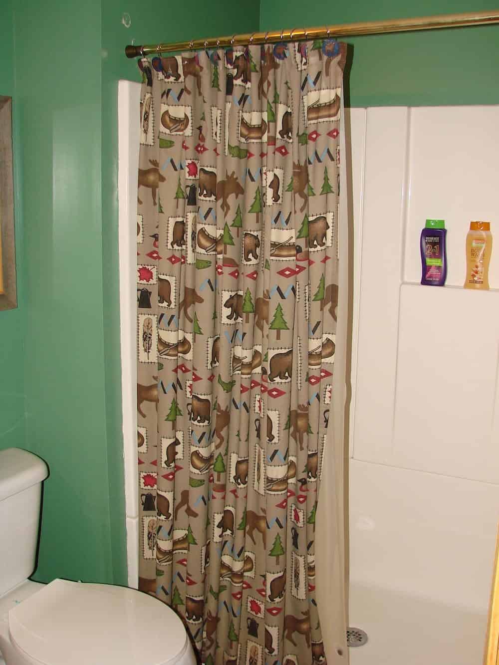 woodland themed shower curtain in a green bathroom