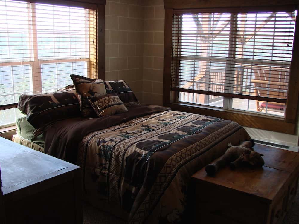 bed in a room with multiple windows